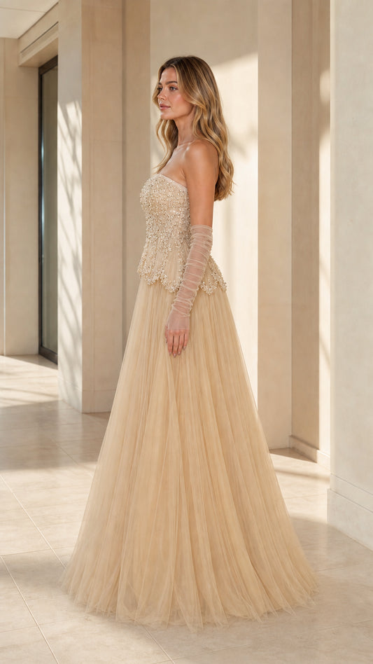 Side angle view of model posing in champagne tulle evening gown
