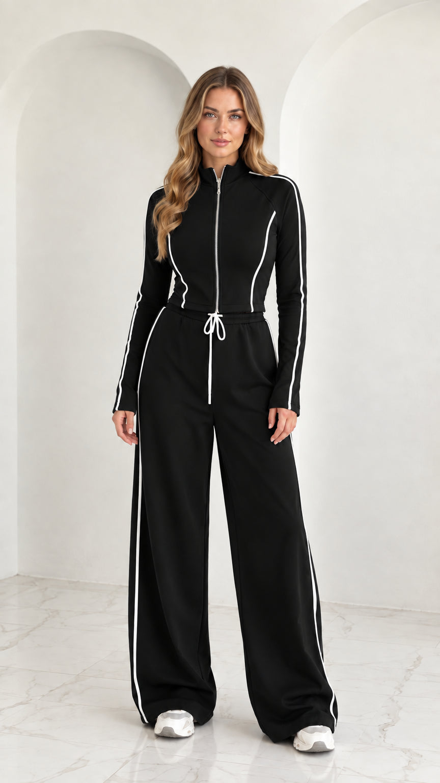 Full front view of model wearing Black 2-piece zip-up tracksuit set with white piping