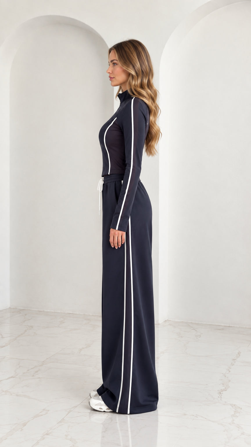 Side profile view of model wearing Navy Blue tracksuit set with vertical white stripe detail
