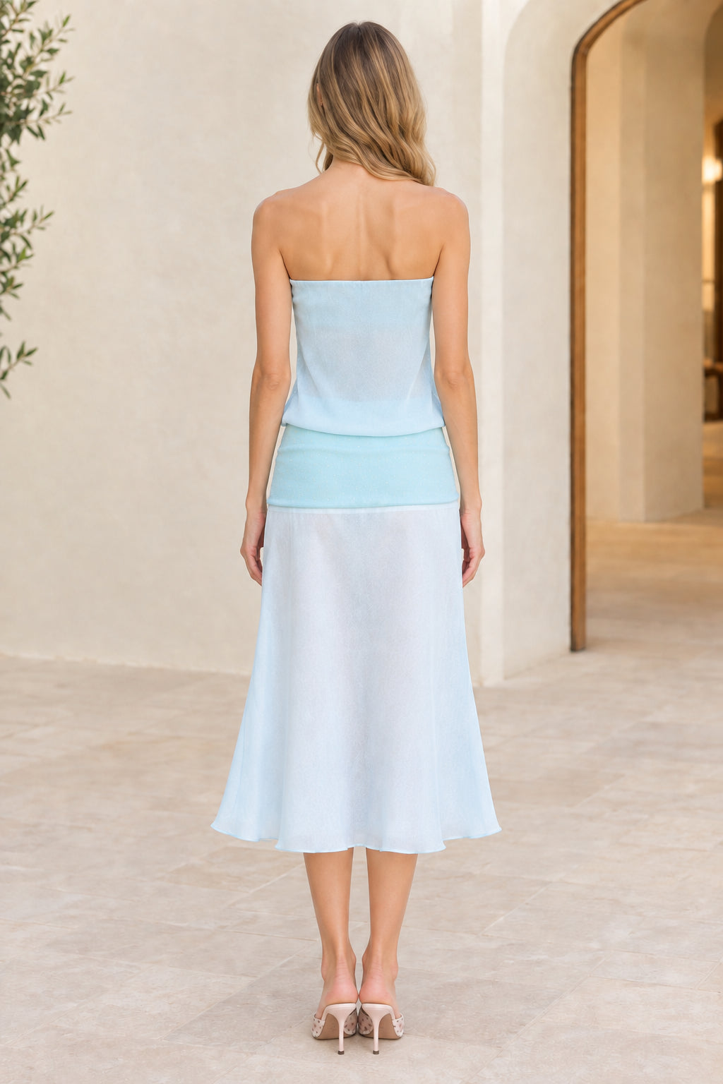 Back view of model wearing light blue strapless midi dress showing smooth back line