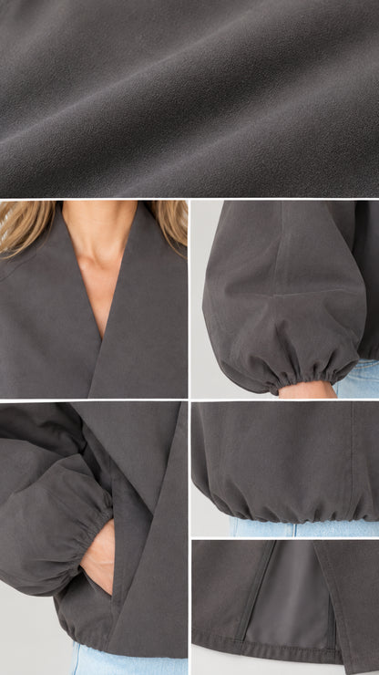 Close-up details of fabric texture, V-neckline, elastic cuffs, and side pockets