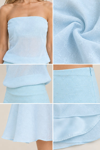 Close-up details of light blue dress fabric texture, neckline, dropped waist, and zipper