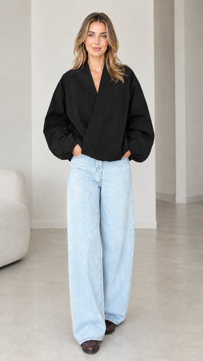 Model wearing Black crossover V-neck balloon sleeve wrap top