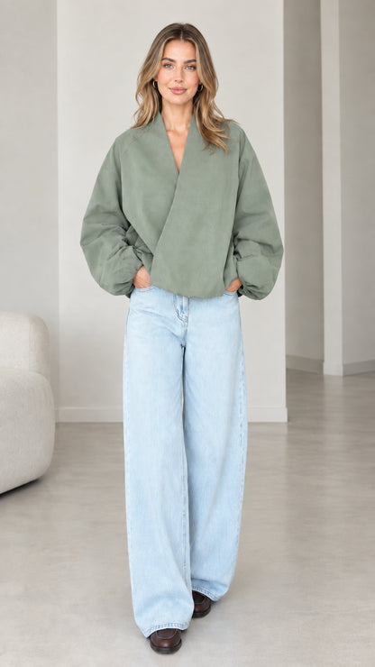 Model wearing Sage Green crossover V-neck balloon sleeve wrap top